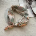 Detailed close-up of a cotton linen floral square scarf featuring orange tulip prints - Orange