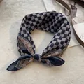 Detail van een zijden sjaal met dambordpatroon in bruin en zwart op een tapijt - Marineblauw Geometrisch