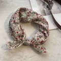 Dettaglio di un foulard in lino a fiori che mostra cuciture fini su uno sfondo morbido - Rosso