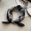 Detailopname van retro geruite en paisley bloemen vierkante sjaal op witte wol - Kant Zwart