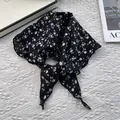 Détail d'un bandana triangulaire noir à fleurs blanches avec bords ourlés et nœud - Noir