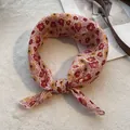 Dettaglio di un foulard di lino con motivi floreali arancioni e pois su sfondo - Girasole