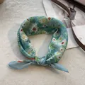 Close-up of a blue floral cotton scarf with daisy print tied as a stylish neck accessory - 58*58cm / Wild Daisy