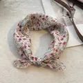 Dettaglio di un foulard quadrato in cotone e lino a fiori annodato su sfondo morbido - Floreale Rosa Verde