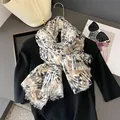 Detailansicht eines Batik-Schals mit Fransen, kombiniert mit Sonnenbrille und Handtasche - Schwarz