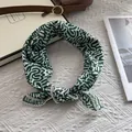 Close-up of cotton square scarf with green wave patterns and delicate lace edge detail - Green