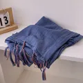 Close-up of deep blue cotton linen scarf featuring colorful tassel trim and crinkled texture - Blue