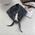Foulard in cotone e lino con fiori e quadretti annodato su una borsa in pelle marrone - Nero