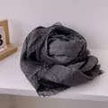 Detailed texture of dark grey cotton scarf featuring elegant black lace trim edges - Black