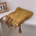 Detail of ginger cotton linen scarf featuring fine pleated texture and colorful tassels - Yellow