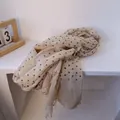 Detalle de bufanda de lino con lunares que muestra textura ligera y bordes deshilachados - Blanco Roto