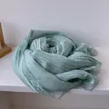 Close-up of light green cotton scarf featuring elegant lace edges and crinkle texture - Aqua Green