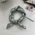Detailed view of dark green linen scarf with leaf patterns and lace embroidery edges - Bandana / Green
