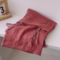 Detail of brick red cotton linen scarf with colorful braided tassels and wrinkled texture - Brick Red