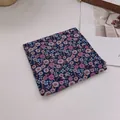 Detailansicht eines Baumwoll-Halstuchs mit Gänseblümchen-Muster auf dunkelblauem Stoff - Wildblumenmuster