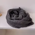 Close-up of charcoal grey linen scarf featuring delicate floral lace trim and texture - Black