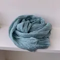 Close-up of dusty blue scarf featuring delicate lace trim and natural pleated texture - Malachite green