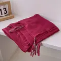 Detail shot of red crinkled linen scarf texture with colorful woven tassel edges - Rouge Red
