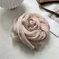 Close-up of texture on light pink linen scarf with raw fringe edges folded as a rose - Brushed Fringe Style / 90x200cm / Pink