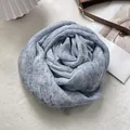 Close-up of light blue linen scarf folded into flower shape with delicate fringe details - Fine Stripe Grid Style / 90x200cm / Blue