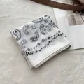 White cotton paisley bandana with black floral patterns on a soft textured background - White Paisley