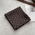 Elegante bufanda de algodón marrón oscuro con lunares blancos sobre fondo blanco - café