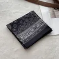 Detailed macro view of black cotton bandana with white floral paisley pattern and stitching - Black Small Flower