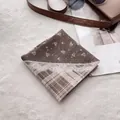 Flat lay of vintage cotton-linen neckerchief with floral pattern and leather bag - Khaki Lace Plaid