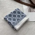 Close-up of blue and white geometric floral pattern on cotton linen bandana scarf - White