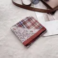 Détail d'un foulard rétro à carreaux et fleurs avec bordure en dentelle sur tapis doux - Rouge Dentelle Plaid