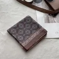 Close-up of folded brown floral bandana with white mandala patterns on a soft rug - Coffee