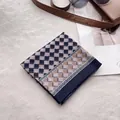 Vue à plat d'un foulard en coton et lin plié avec des motifs géométriques bleu marine - Bleu Marine Damiers