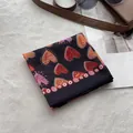 Detailed top view of a black linen headscarf with heart prints and fashion accessories - Heart