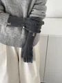 Detail of dark grey knit wool gloves with long ribbed cuffs and gold buckle decorative label - Dark Gray