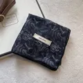 Detail of floral cotton linen scarf with 'explore infinity' tag and vintage pattern - Black