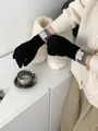 Detail of black knit touchscreen gloves with grey striped ribbed cuffs and round fabric label - Black And Dark Grey