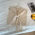 Detalle de chal de punto blanco crema con textura de gofre y elegante diseño de lazo frontal - Blanco Roto
