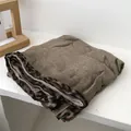 Primer plano de bufanda de algodón y lino marrón con detalle de borde de leopardo - 90x180cm / Caqui