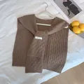 Primer plano del chal de punto gofrado marrón con textura gruesa y etiqueta tejida - Camel