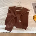 Primer plano de chal de punto marrón oscuro con textura de cuadros y cintas - Café