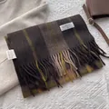 Détail d'une écharpe en cachemire à carreaux avec pompons et étiquette blanche - 180x30cm / café