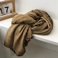 Detail of dark camel cotton scarf featuring stylish leopard print edges and soft texture - 90x180cm / Yellow
