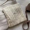 Detail of cable knit wool scarf with 100% wool label and ribbed texture in cream white - Ivory