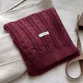 Dettaglio della sciarpa in lana bordeaux a trecce con etichetta 100% pura lana - Rosso Ancorra