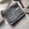 Vista detallada de la textura de bufanda 100% lana con etiqueta KILDI hecha a mano - Gris