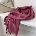 Dettaglio della sciarpa in cotone e lino rosso scuro con trama a nido d'ape e nappe morbide - Colore carminio