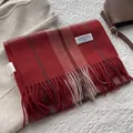Gros plan sur l'étiquette de marque et les franges d'une écharpe rayée en cachemire - 180x30cm / Rouge