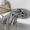 Dettaglio della sciarpa in cotone e lino grigia con nappe rustiche e perle di legno - Grigio