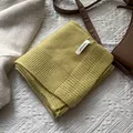 Detalle de bufanda de 100% pura lana en color amarillo jengibre con textura de punto grueso - Amarillo