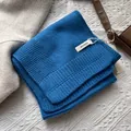 Primer plano de la etiqueta 100% lana que muestra la textura de punto azul - Azul sal marina